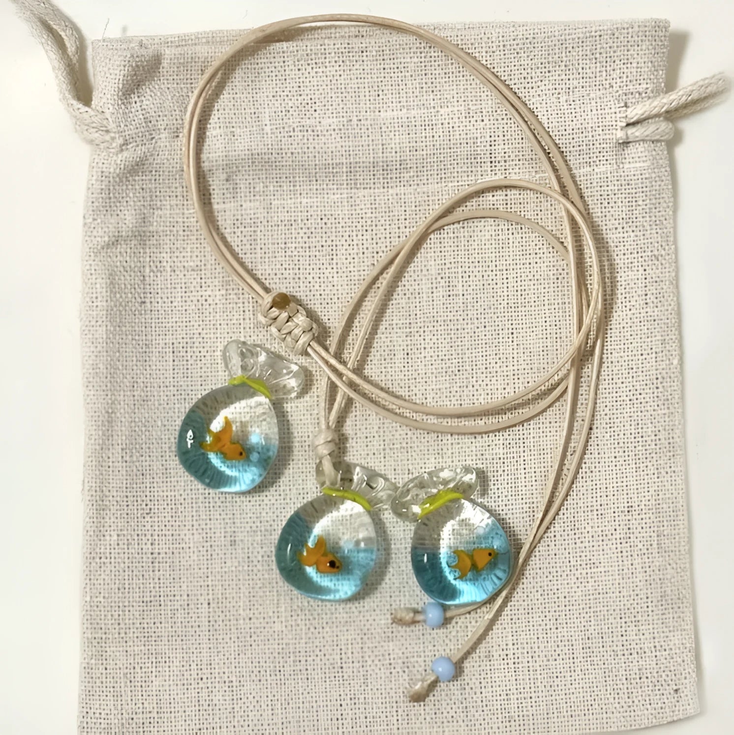 Women's coloured glaze pendant necklace on a beige cotton-linen cord, showing Skirt and Joker design details.