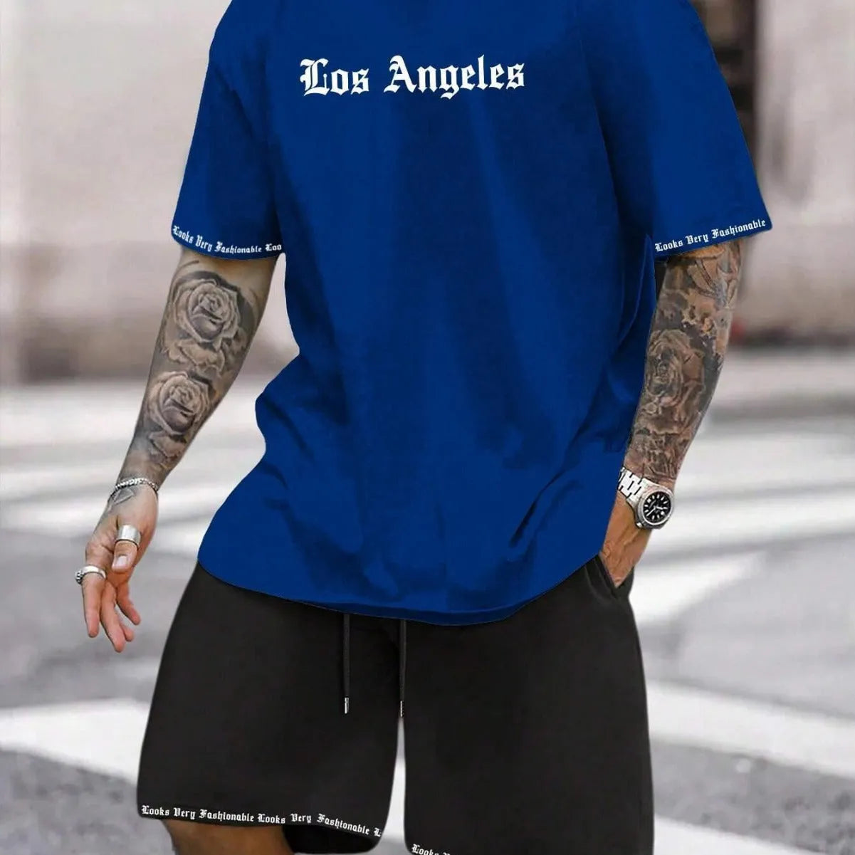 Man wearing a printed short-sleeve top and matching shorts from a sports style suit set.