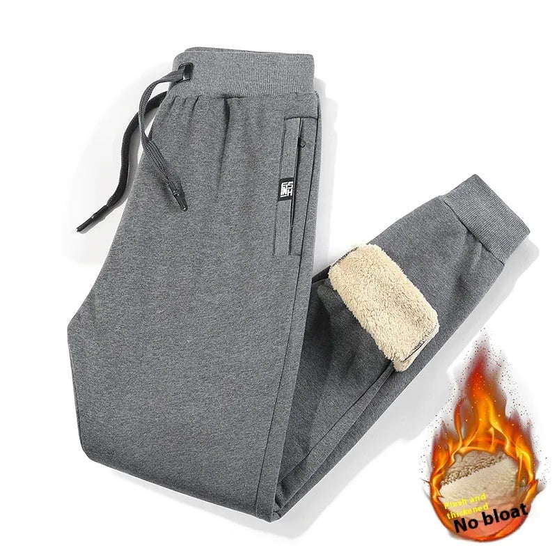 Men's grey fleece-lined cotton oversized track pants with a straight leg, laid flat.