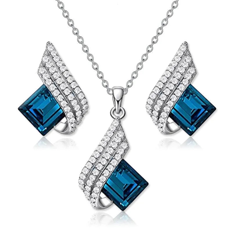 Silver-toned necklace and earrings set with glass pendant on cross chain