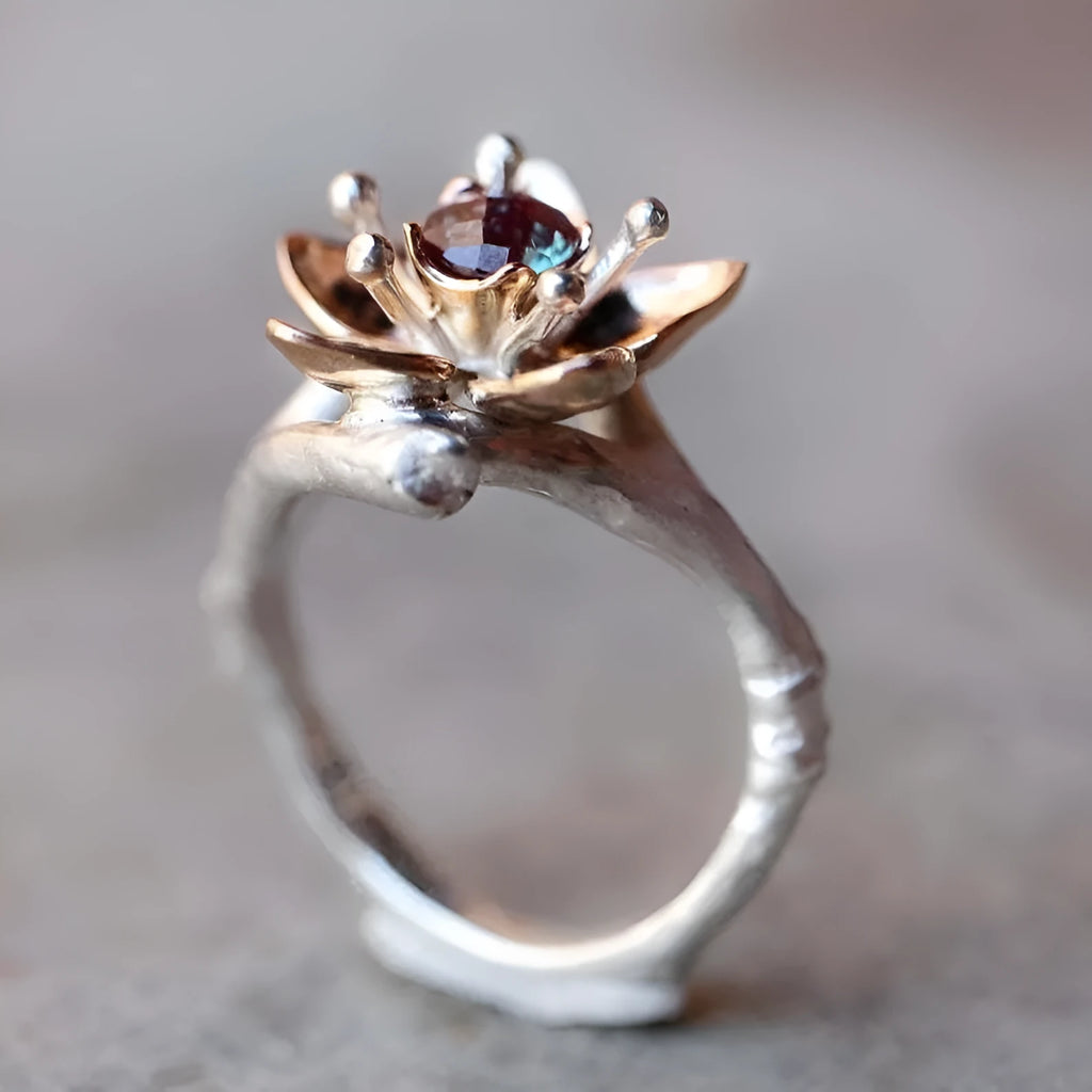 Silver two-tone women's ring with a geometric floral pattern on a white background.