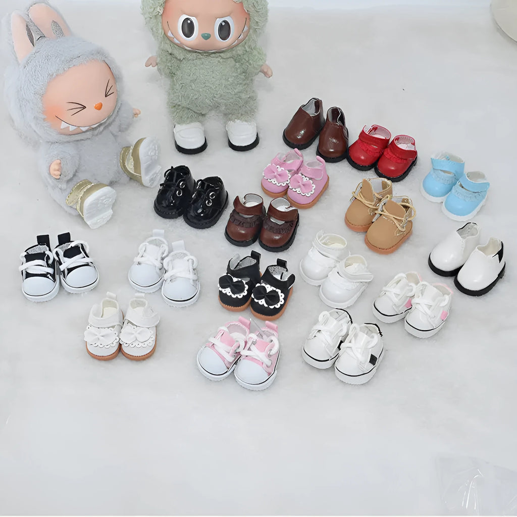 Pair of miniature black boots for a 17cm fashion doll on a white background.