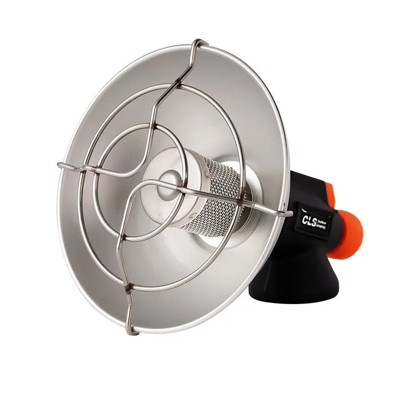 Black and orange portable camping stove with automatic ignition on a rocky outdoor surface.