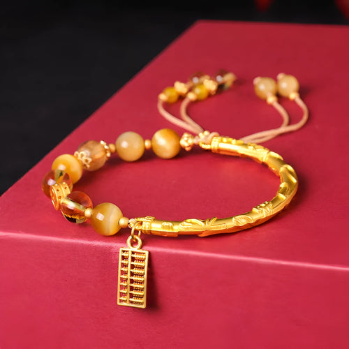 Handmade beaded bracelet featuring tigereye and citrine stones with yellow tower crystal and diamond-shaped copper parts