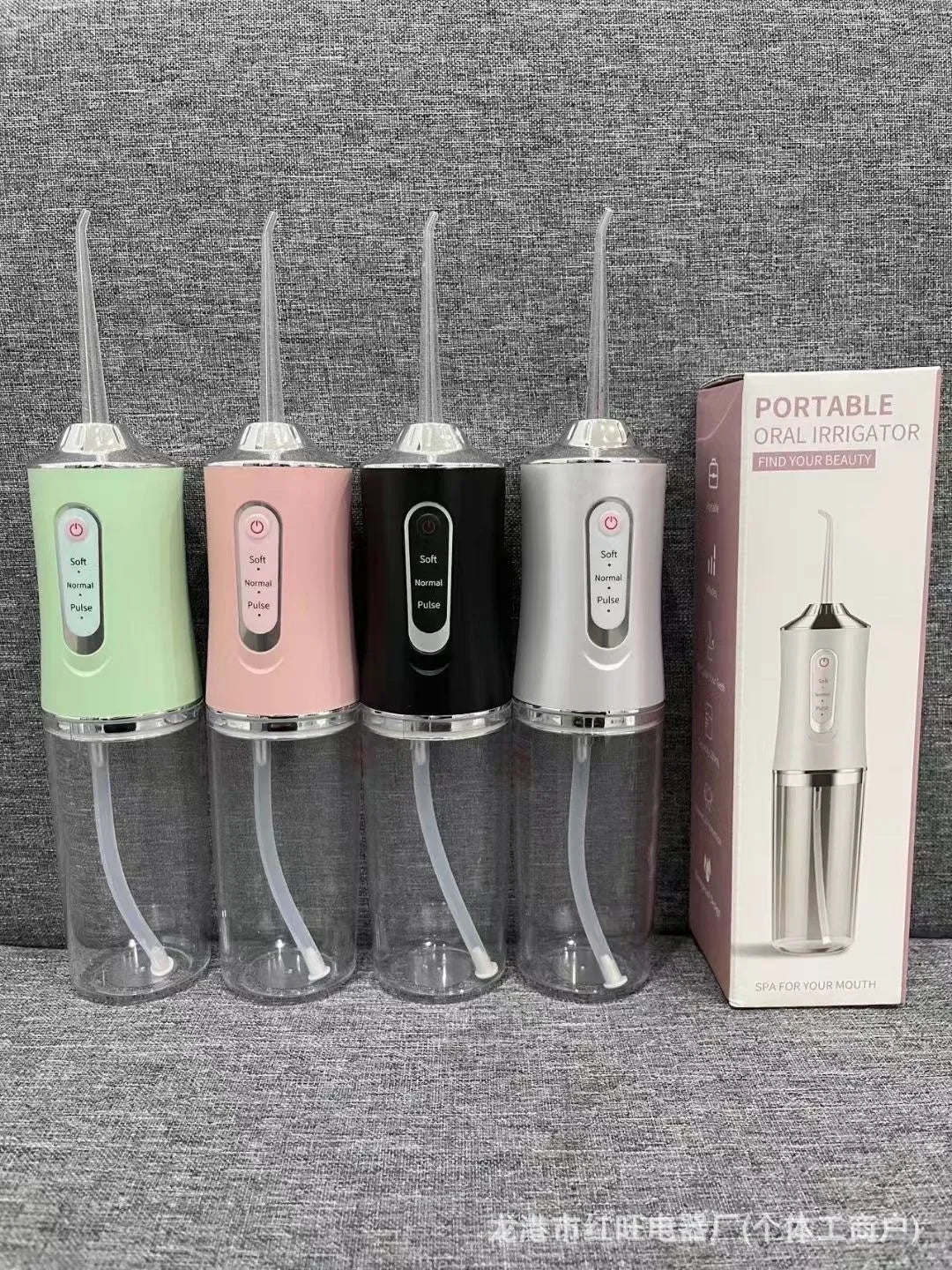 Pink portable electric water flosser with replaceable nozzles and large water tank on bathroom counter