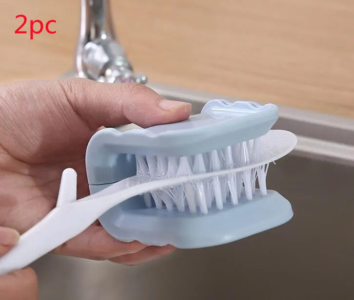 Blue U-shaped plastic brush for cleaning kitchen forks, knives and spoons on a countertop.