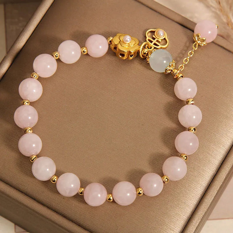 Women's pink crystal bracelet with a refined grace flower design on a wrist.