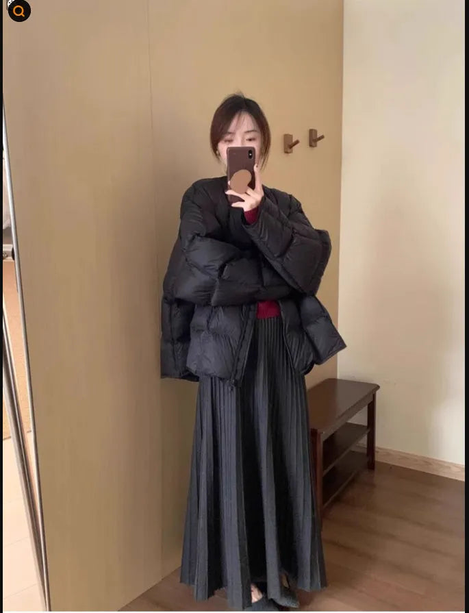 Dark grey knitted women's sweater and skirt set with a raised 3D pattern, laid flat.