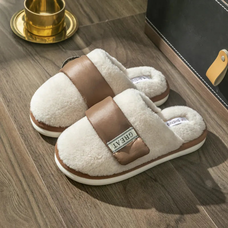 Beige women's plush slippers with a Velcro strap and non-slip plastic sole on a wooden floor.