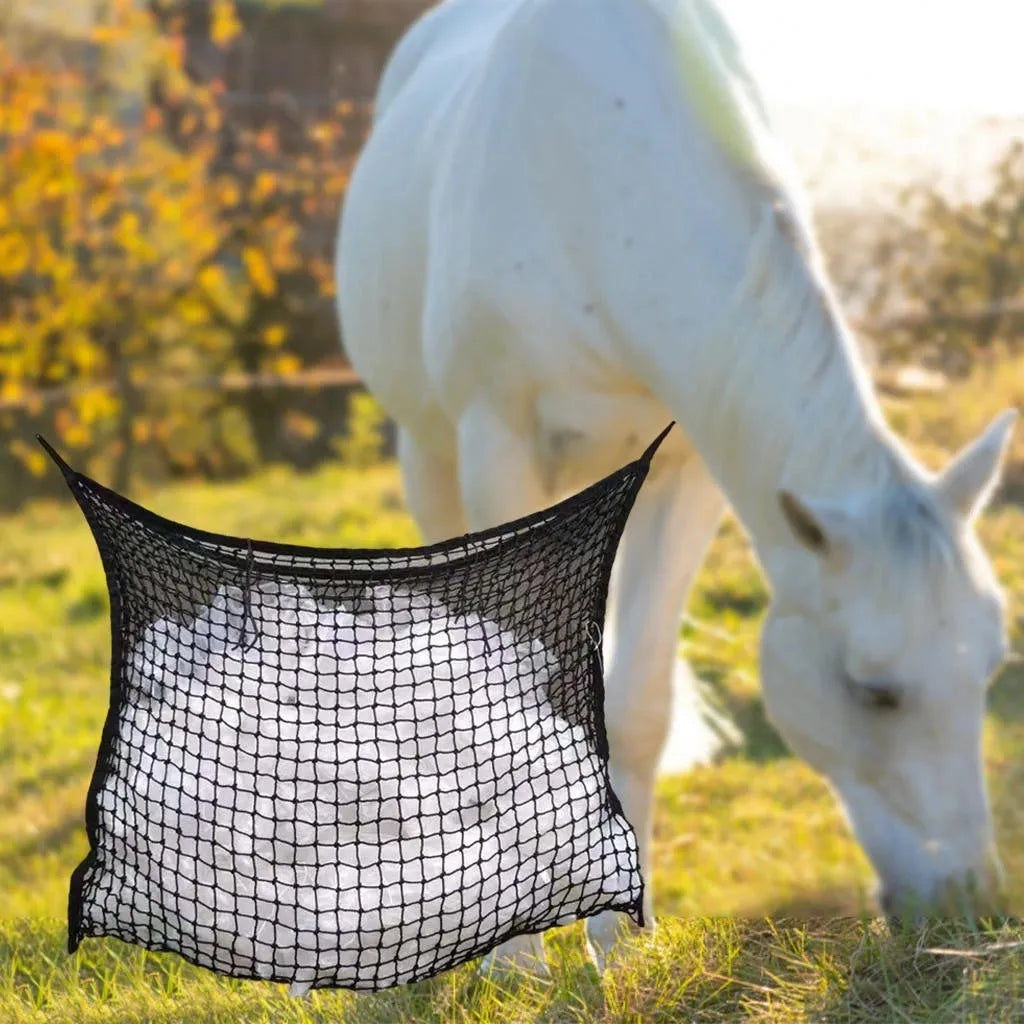 Black woven grid horse feeding bag hanging, filled with hay.