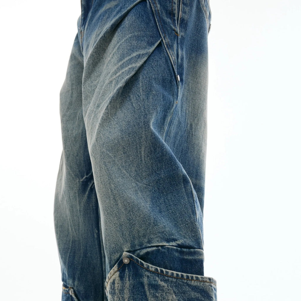 Man wearing verdant blue loose-fit jeans with a curved knife burst pattern on the thighs.