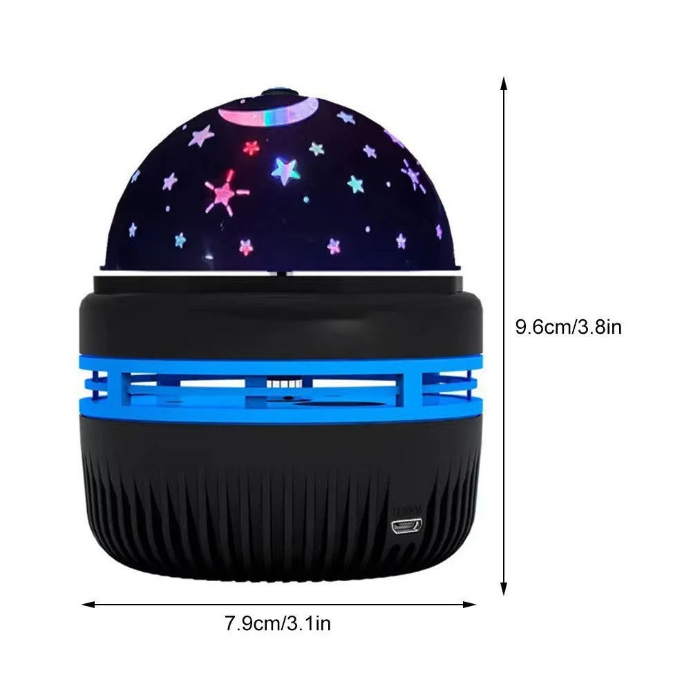 Compact white LED star projector lamp on a table, projecting galaxy light patterns on a dark wall.