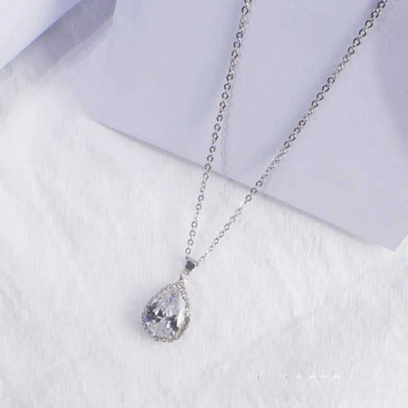 Rose gold water drop shaped necklace with geometric design and rhinestone accents in pink colour