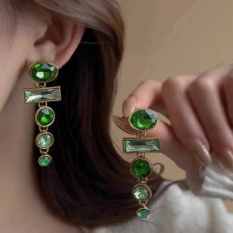 Pair of green gradient geometric ear studs with zircon details and a long tassel, on a white background.