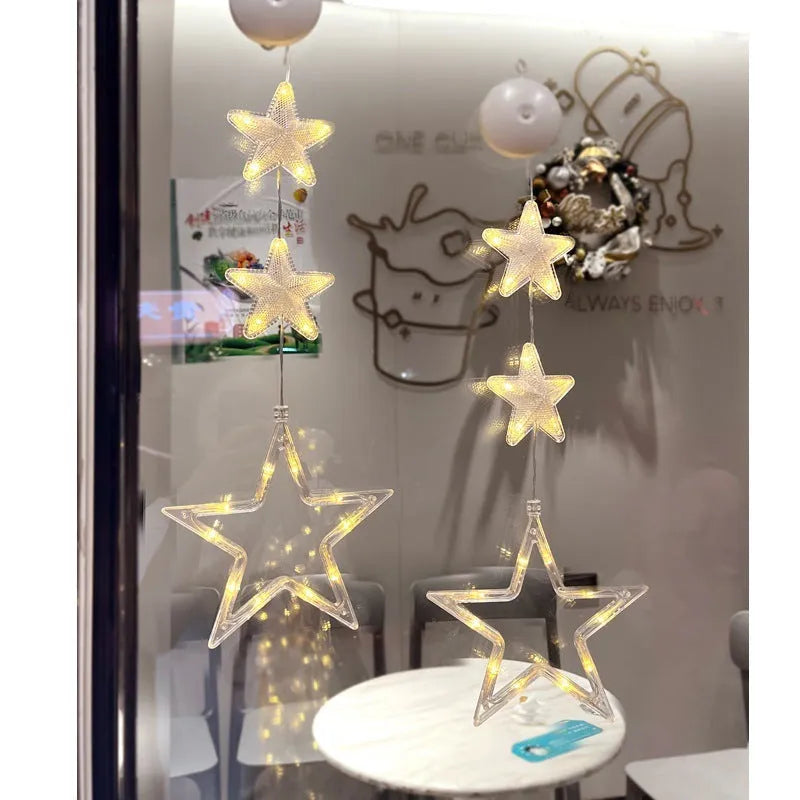 Set of three Christmas LED light pendants with suction cups, showing star, deer, and tree designs on a window.