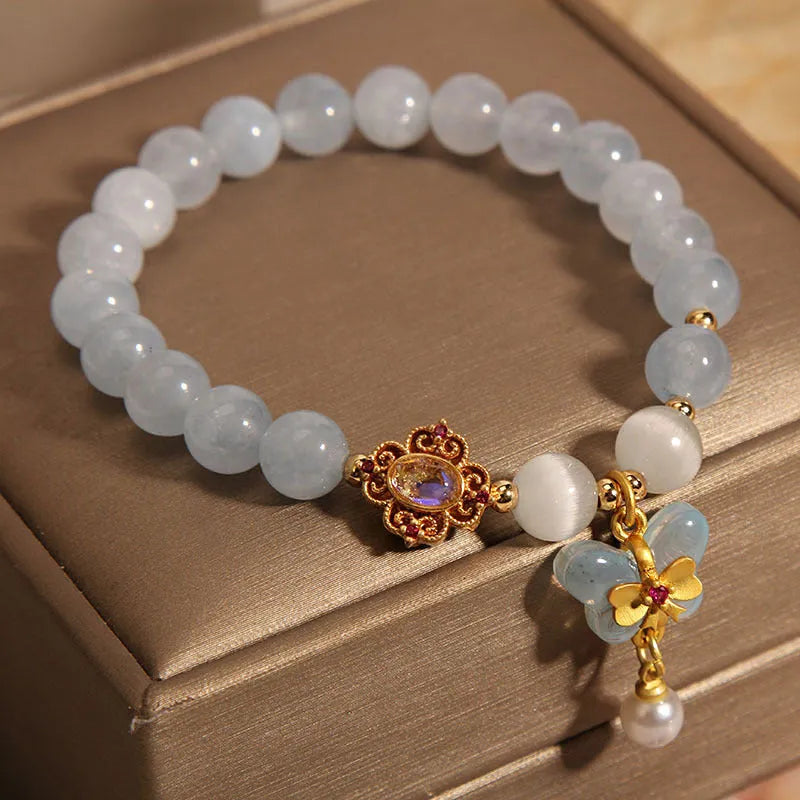 Women's adjustable bracelet with an aquamarine crystal butterfly pendant and rhinestone details on a metal chain.