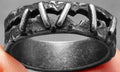 Dark punk stitching style stainless steel double ring on a size guide showing options 7 to 15.