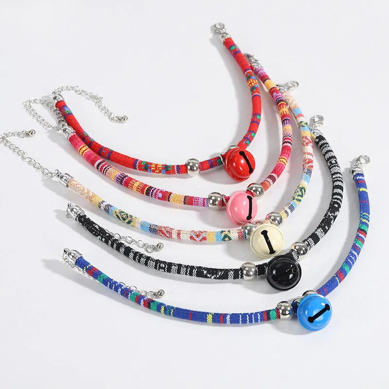 Adjustable ethnic-pattern pet collar with metal bell in blue, showing buckle and size tag.