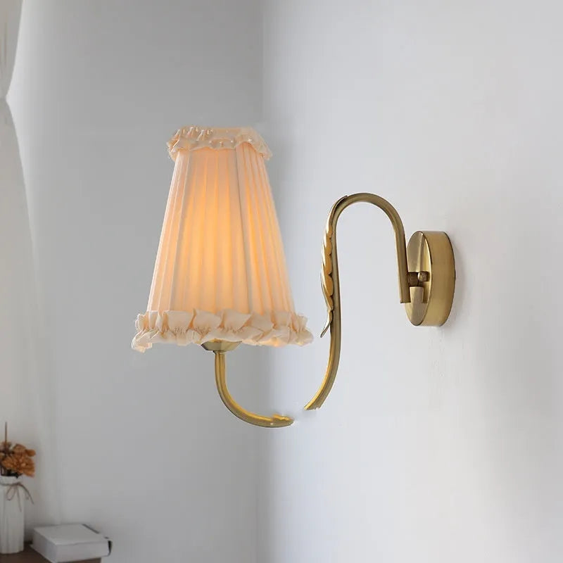 Wheat wall lamp with fabric shade and iron frame mounted on a bedroom wall with warm non-stroboscopic light