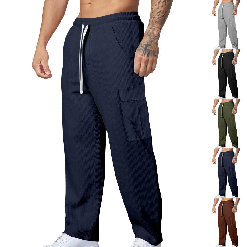 Men's loose-fitting corduroy cargo trousers in a brick red colour with a wide-leg silhouette.