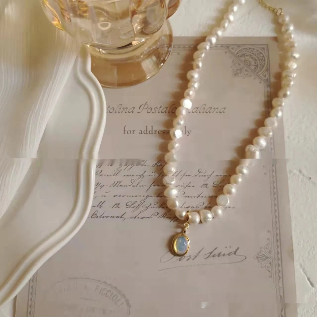 Vintage geometric pearl necklace with adjustable chain on a dark background.