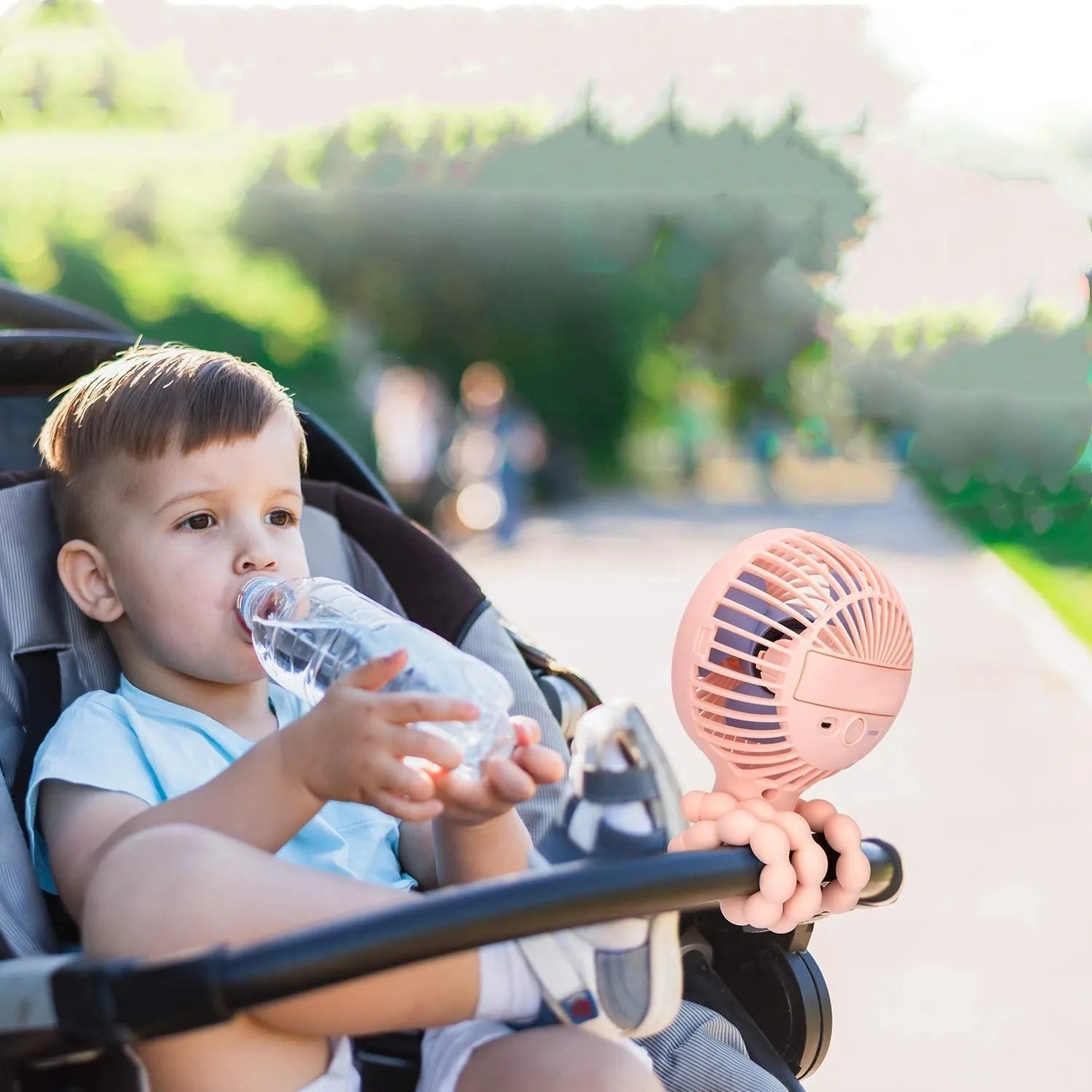 Pink portable USB rechargeable fan with animal design and clip attached to a stroller handle.