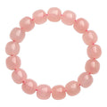 Pink natural crystal barrel bead bracelet with geometric design on wrist