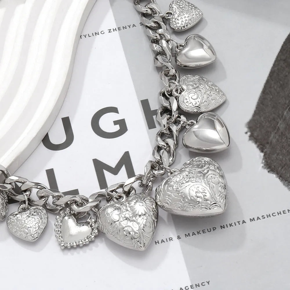 Carved heart-shaped pendant necklace on a metal chain, shown in gold and white K colour options.