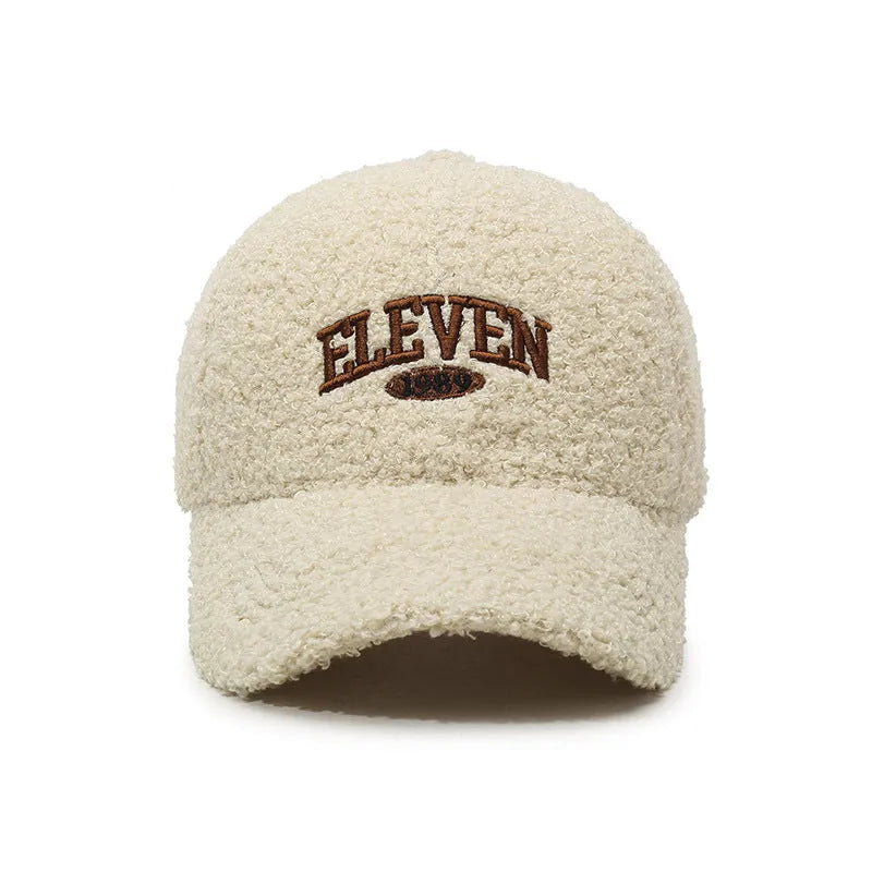 Adjustable lambskin winter baseball cap in black with dome crown and machine embroidery detail.