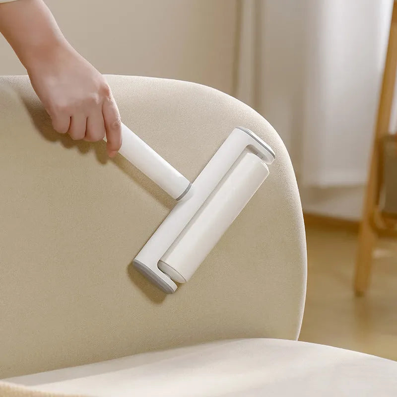 Handheld pet hair lint roller with a sticky paper surface on a yellow core.