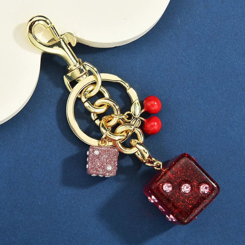 Vintage-style metal keychain with a square cherry red and white two-tone dice pendant on a metal ring.