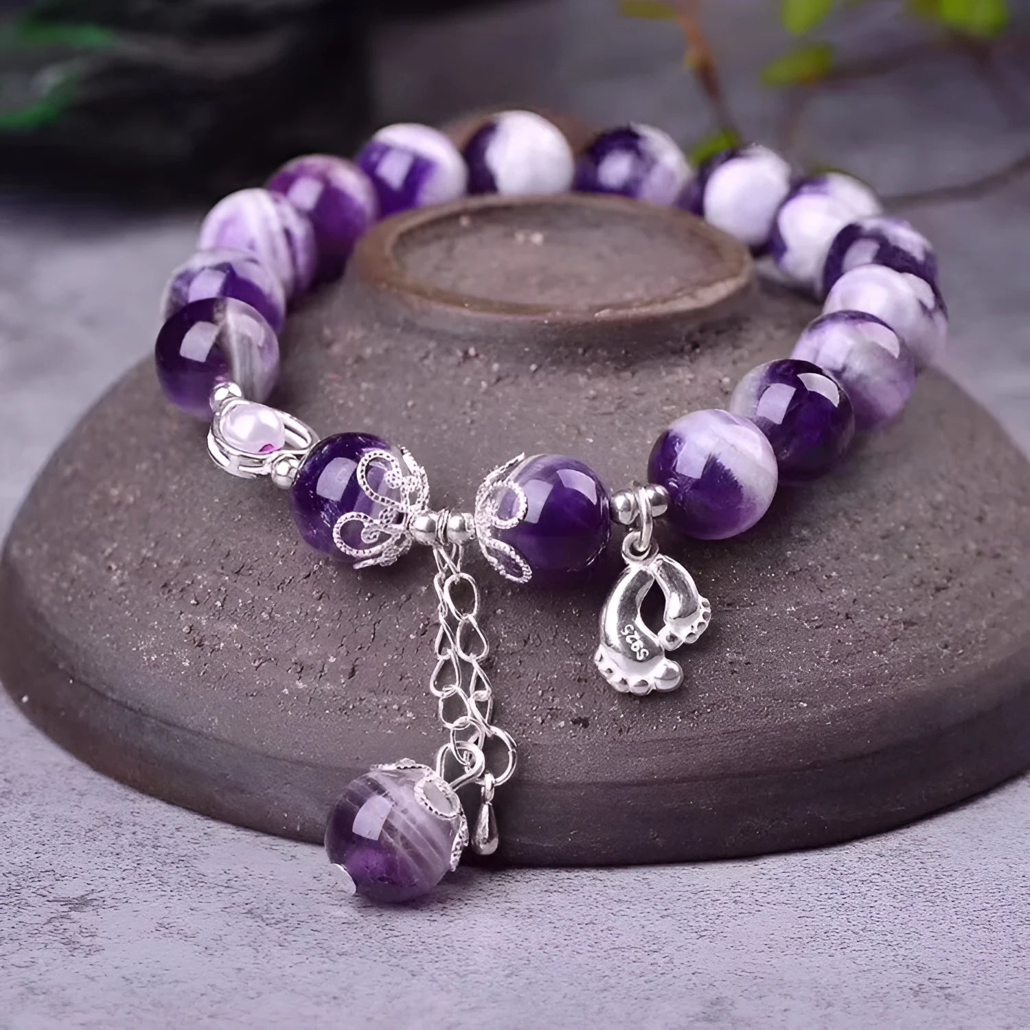 Women's amethyst bracelet with 10mm round purple beads on a wrist.