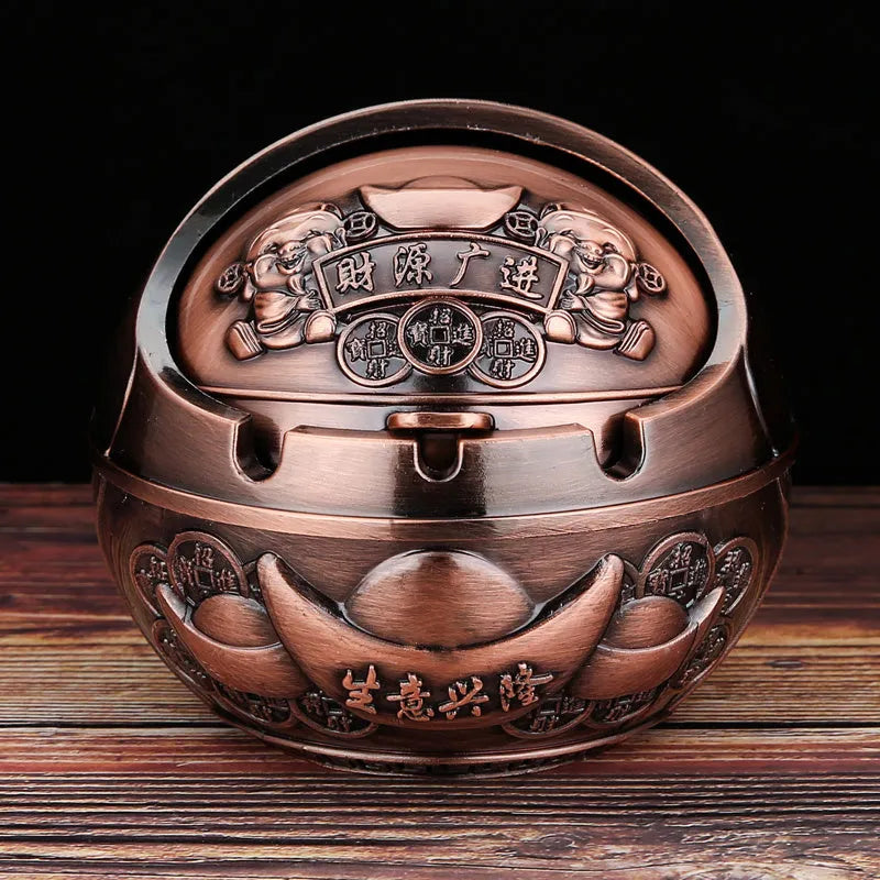 Alloy decorative ashtray in bronze with ornate peacock motif and cigarette extinguishing slot.