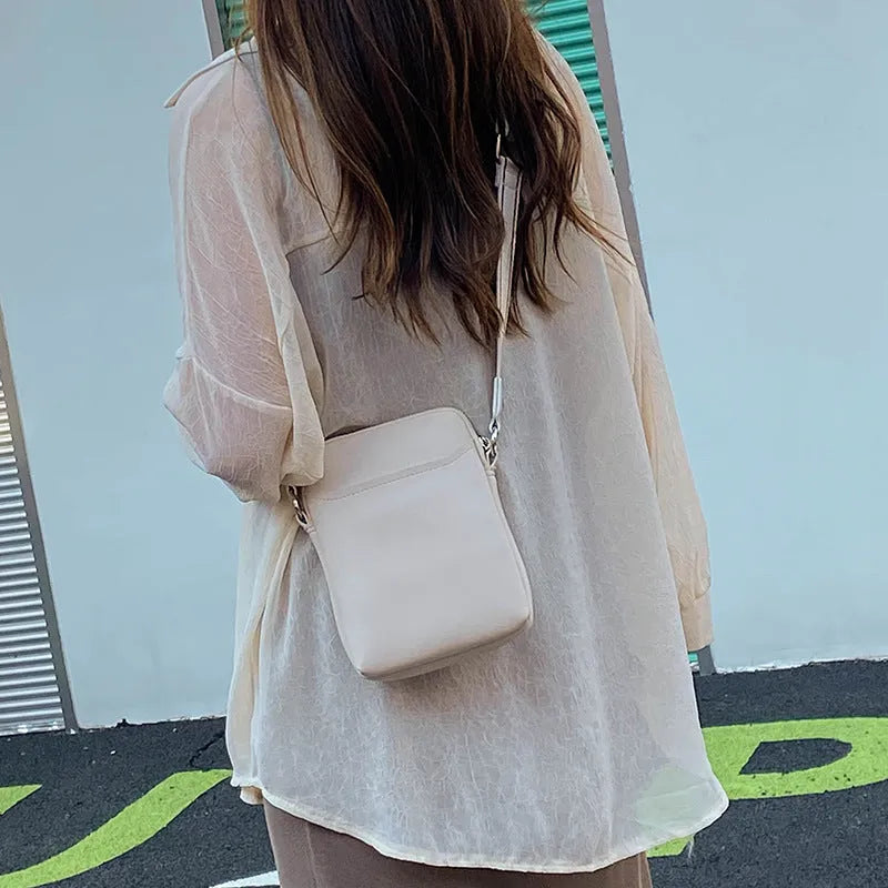 Solid colour crossbody phone bag for women in black, made from PU with an adjustable strap.
