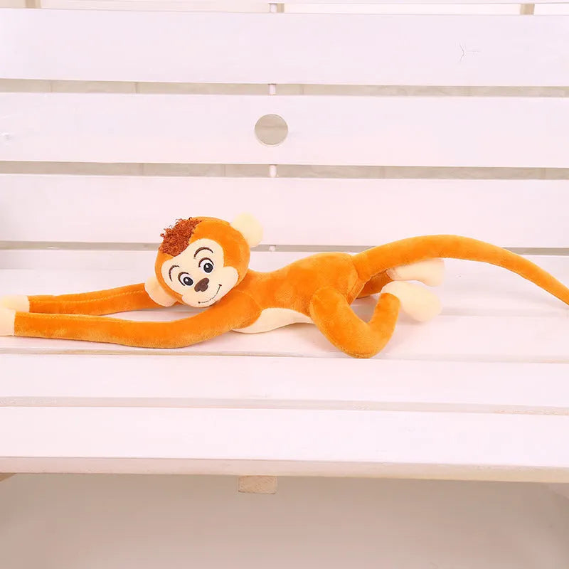 Long arm pink plush monkey toy hanging over a curtain rod as room decoration.