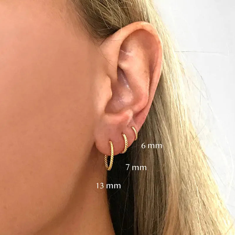Sterling silver twisted string round hoop earrings in gold colour, showing geometric detail.