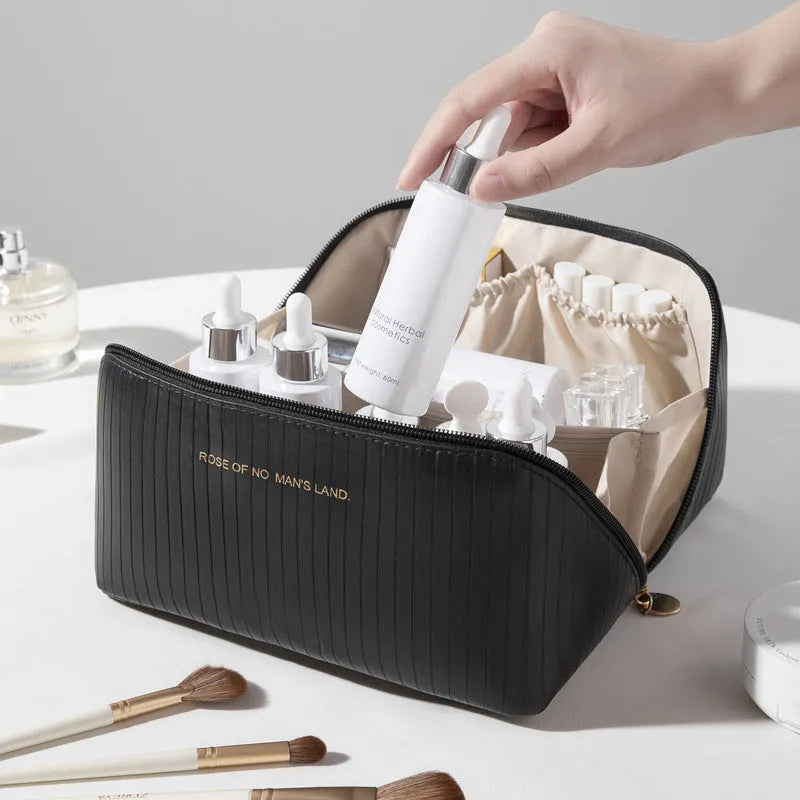 Vertical pattern pillow-shaped cubic makeup bag in PU material, shown in a neutral colour.