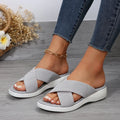 Black women's peep-toe slippers with a cross strap and thick flat rubber wedge sole.
