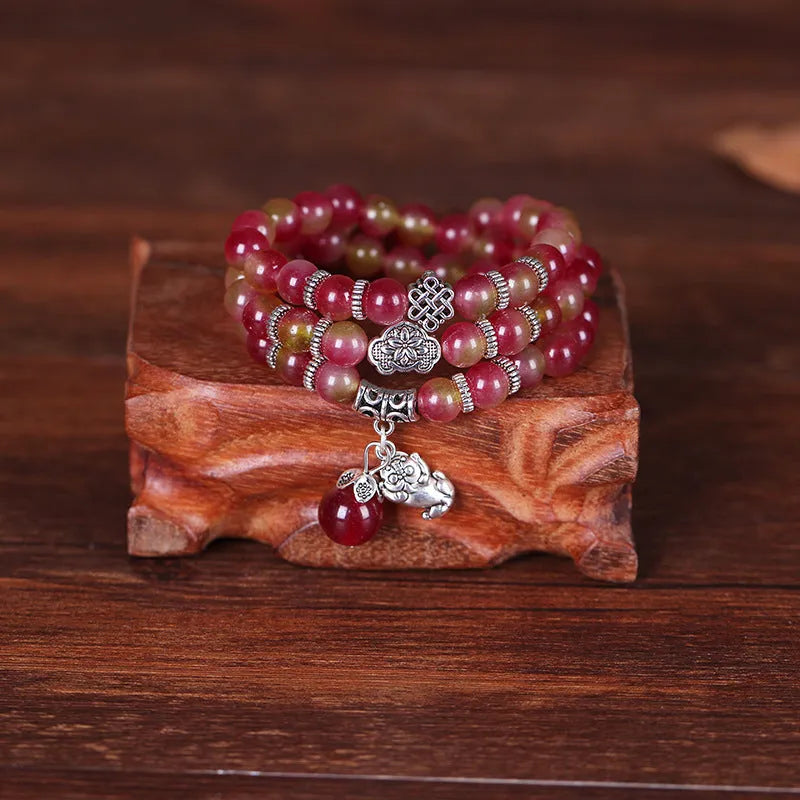 Handmade bracelet with geometric watermelon crystal beads and a Chinese knot closure.
