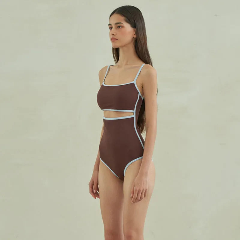 Brown women's one-piece triangle swimsuit on a hanger, showing nylon fabric texture.