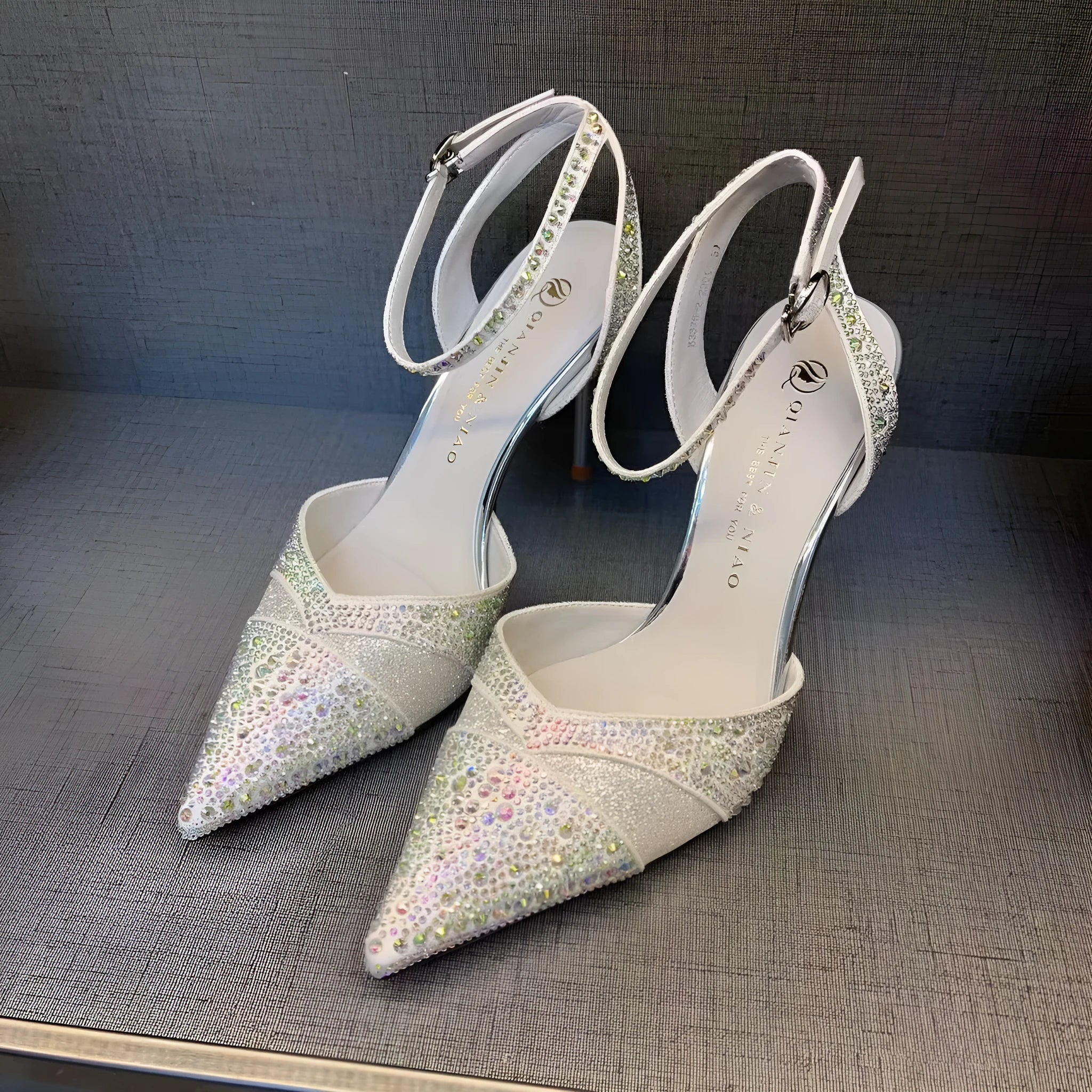 Women's black pointed-toe stiletto heels with a hollow-out design and red sole.
