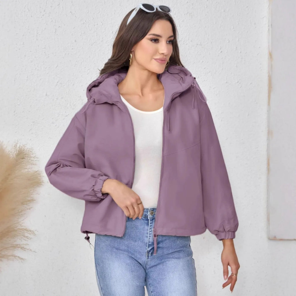 Grey loose-fit women's hooded shell jacket with long sleeves on a hanger.