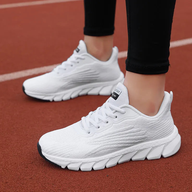 Low-top black and white running sneaker with cross strap and round toe on MD sole.