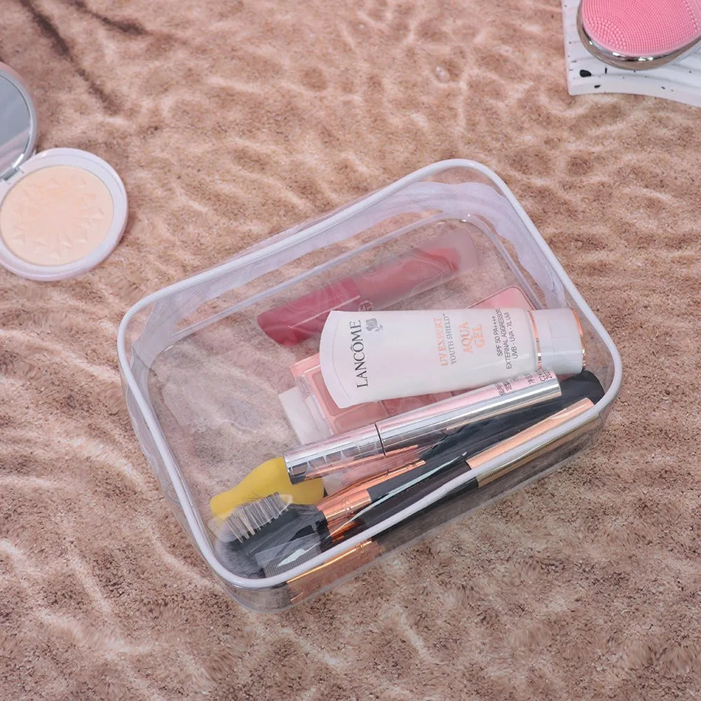 Three semi-transparent PVC makeup bags in black, pink and white colours showing cosmetic storage