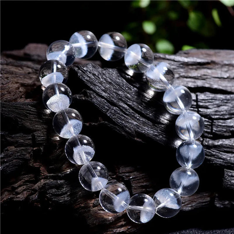 Women's natural white crystal bracelet with a pyramid charm and ruyi charm, showing spherical beads.
