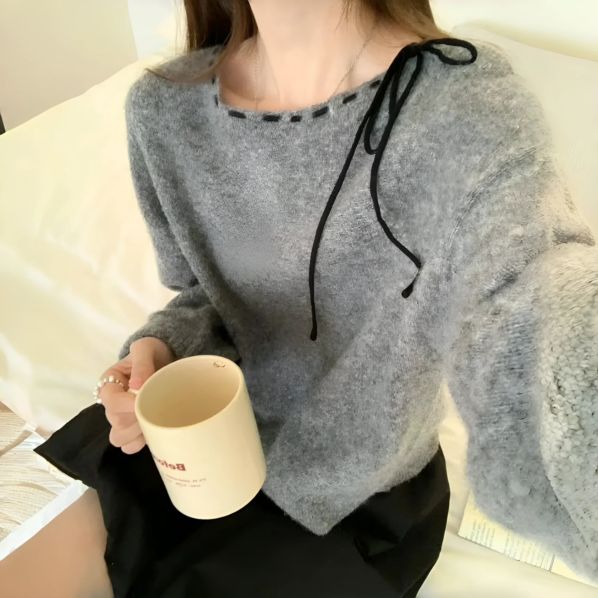 Grey loose-fitting women's long-sleeve knitwear pullover on a hanger.