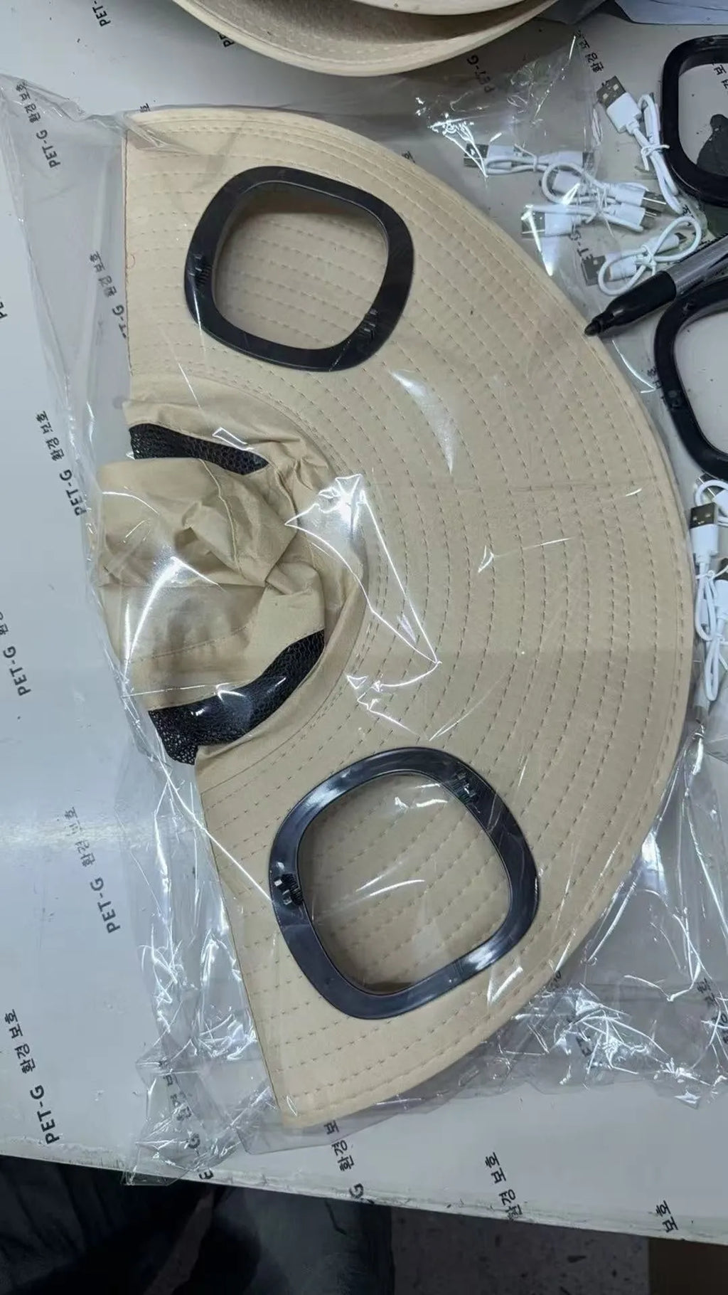Man's grey solar fan cap with large brim and a small solar panel and fan visible on the front.