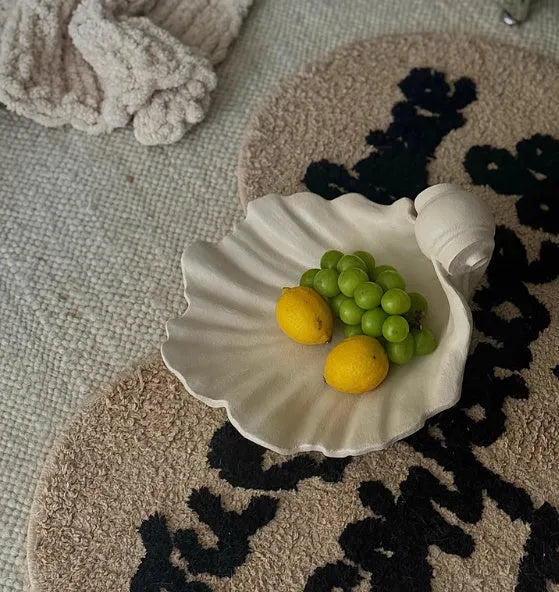 White resin fruit plate ornament with simulated shell storage design on wooden table