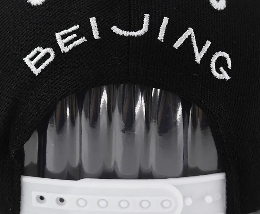 Adjustable black cotton baseball cap with embroidered lettering on the front, showing dome crown shape.