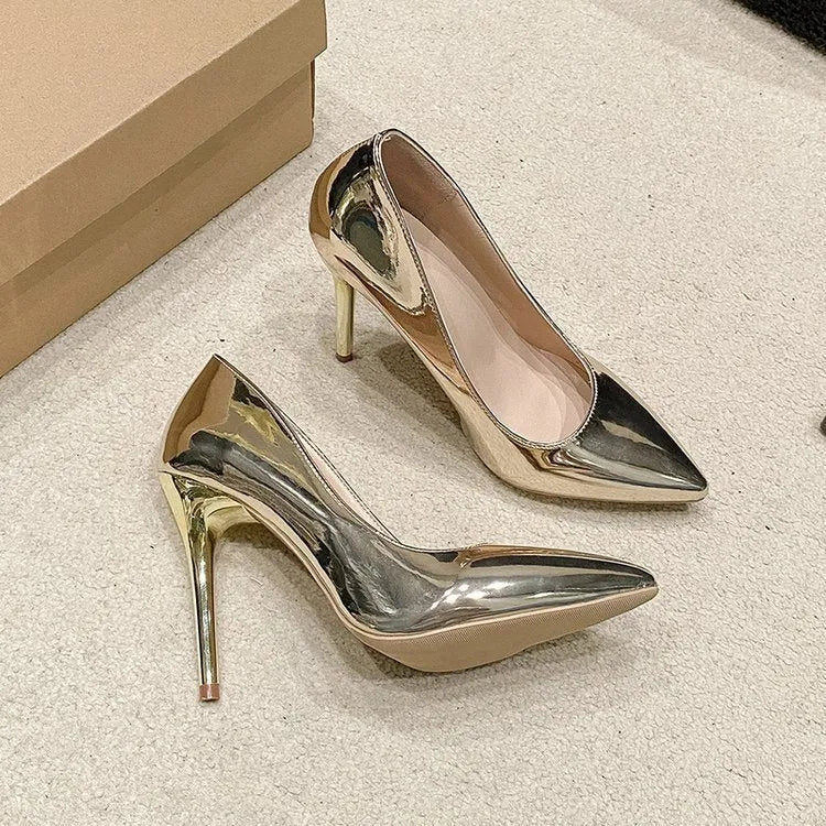 Gold and silver pointed toe slip-on stiletto heel pumps on a white background